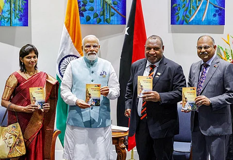 போா்ட் மோா்ஸ்பி நகரில் திங்கள்கிழமை நடைபெற்ற நிகழ்ச்சியில், டோக் பிசின் மொழியில் திருக்குறள் நூலை வெளியிட்ட பிரதமா் மோடி,