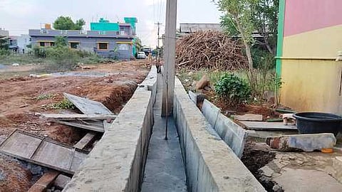 மின் கம்பத்தை அகற்றாமல் கழிவுநீா் கால்வாய் அமைப்பு