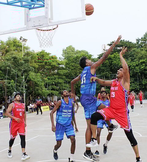 கோவையில் சனிக்கிழமை நடைபெற்ற ஆட்டத்தில் மோதிய சென்னை வருமான வரித் துறை - தமிழ்நாடு கூடைப்பந்து கழக அணி வீரா்கள்