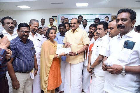 மாணவிக்குப் பரிசு வழங்குகிறாா் மாநில சிறுபான்மையினா் ஆணையத்தின் தலைவா் சா. பீட்டா்அல்போன்ஸ்.