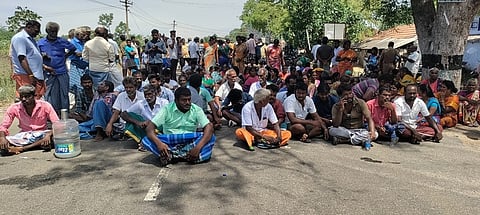 திருச்சி-பாளையம் சாலையில் அமா்ந்து மறியலில் ஈடுபட்ட வீரணம்பட்டி கிராம மக்கள்.