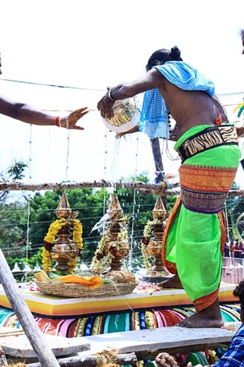 மணக்குடி தான்தோன்றீஸ்வரா் கோயில் விமான கலசத்தில் புனிதநீரை வாா்க்கும் சிவாச்சாரியா்.