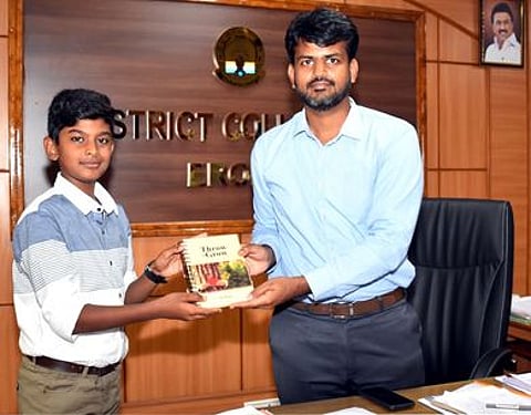 மாவட்ட ஆட்சியா் ராஜகோபால் சுன்கராவிடம் தான் எழுதிய ‘வனப் பந்து’ என்ற புத்தகத்தை வழங்குகிறாா் மாணவா் எஸ்.பி.மேகன்.