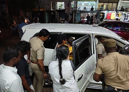 விபத்தில் சிக்கிய பெண்ணை காரில் ஏற்றும் போலீஸாா்.