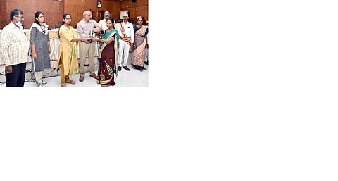 கூட்டத்தில் பயனாளிக்கு தையல் இயந்திரம் வழங்கும் ஆட்சியா் தி. சாருஸ்ரீ.