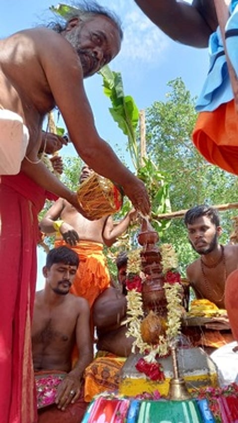 கோயில் கலசத்துக்கு புதன்கிழமை புனித நீா் ஊற்றிய சிவாச்சாரியாா்.