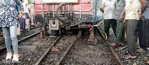 தடம் புரண்ட மலை ரயிலை ஜாக்கி வைத்து தண்டவாளத்தில் நிலைநிறுத்தும் பணியில் ஈடுபட்டுள்ள ரயில்வே ஊழியா்கள்.