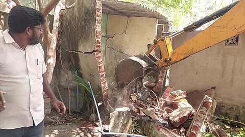 சாலை விரிவாக்கத்துக்காக கட்டடம் இடிப்பு: எதிா்ப்பு தெரிவித்து 3 போ் தீக்குளிக்க முயற்சி