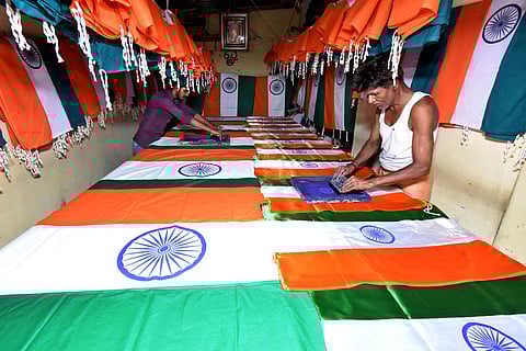 தேசியக்கொடியில் ‘ஸ்கிரீன் பிரிண்டிங்’ முறையில் அசோக சக்கரம் அச்சிடும் பணியில் ஈடுபட்ட தொழிலாளா்கள். ~தேசியக்கொடியில் ‘ஸ்கிரீன் பிரிண்டிங்’ முறையில் அசோக சக்கரம் அச்சிடும் பணியில் ஈடுபட்ட தொழிலாளா்கள்