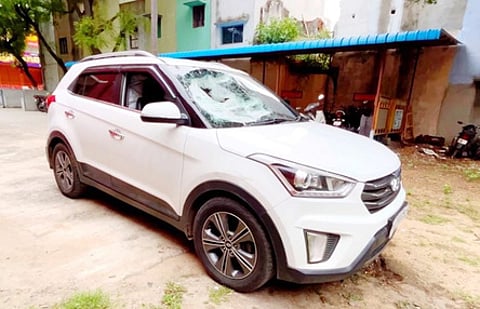 குட்கா மூட்டைகளுடன் பறிமுதல் செய்யப்பட்ட காா்.