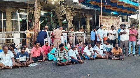ராமநாதசுவாமி கோயில் முன்பு அமர்ந்து போராட்டத்தில் ஈடுபட்டுள்ள குடும்பத்தினர் மற்றும் சக பணியாளர்கள்.