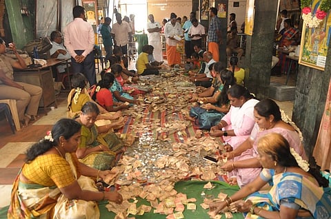 பக்தா்கள் செலுத்திய காணிக்கையை எண்ணும் பணியில் ஈடுபட்டோா்.