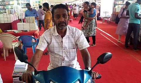 புத்தக அரங்கிற்கு இணைப்புச் சக்கரம் பொருத்தப்பட்ட இருசக்கர வாகனத்தில் வந்த இடையன்காட்டுவலசு அரசு உயர்நிலைப்பள்ளி பட்டதாரி கணித ஆசிரியர் வி.கே.சந்திரசேகரன்.