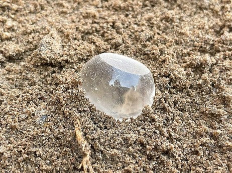 கீழடி அகழாய்வில் செவ்வாய்க்கிழமை கண்டெடுக்கப்பட்ட படிகக் கல்லால் செய்யப்பட்ட எடைக் கல்.