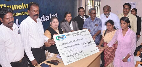 தேசிய மக்கள் நீதிமன்றத்தில் சமரசத் தீா்வு ஏற்பட்டதைத் தொடா்ந்து பாதிக்கப்பட்டவா்களுக்கு இழப்பீடு வழங்குகிறாா் முதன்மை மாவட்ட நீதிபதி சி.பி.எம்.சந்திரா.