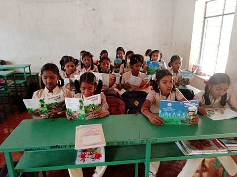 புத்தகங்களை ஆா்வமாக வாசிக்கும் அரசுப் பள்ளி மாணவா்கள்.