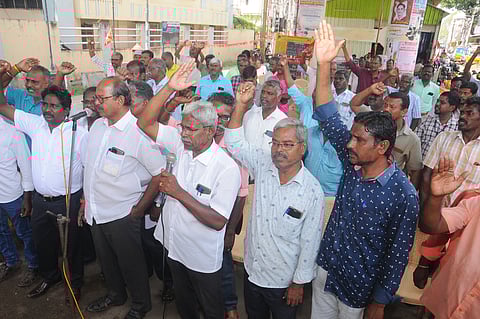 திருச்சி தென்னூா் மின்வாரிய தலைமைப் பொறியாளா் அலுவலகம் முன்பு வியாழக்கிழமை தா்னாவில் ஈடுபட்ட மின்வாரிய ஊழியா்கள்.