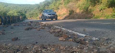 தொடா் மழையால் கணவாய் சாலையில் கிடக்கும் கற்களால் விபத்து ஏற்படும் அபாயம்