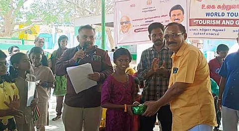 உலக சுற்றுலா தினப் போட்டியில் வெற்றி பெற்ற மாணவிக்குப் பரிசு வழங்கிய தோரணமலை பரம்பரை அறங்காவலா் செண்பகராமன்.