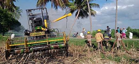 வயலில் இருந்தகதிா் அறுக்கும் வாகனம்தீப்பற்றி எரிந்து சேதம்
