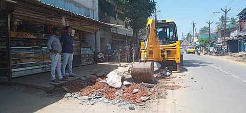கீழ்வேளூா் பேருந்து நிறுத்தம் அருகே ஆக்கிரமிப்புகளை அகற்றும் நெடுஞ்சாலைத் துறையினா்.