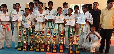 கராத்தே போட்டியில் சாம்பியன் பட்டம் வென்ற மாணவ, மாணவியா்.