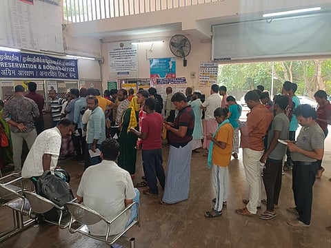 ரயில் நிலையத்தில் பயணச்சீட்டு எடுக்க காத்திருந்த பயணிகள்.