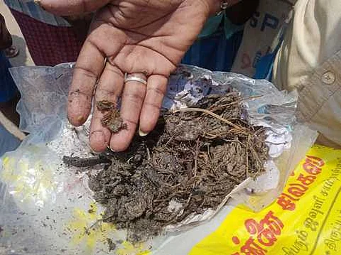 குடிநீா் தொட்டியிலிருந்து எடுக்கப்பட்ட மாட்டுச் சாணம்.