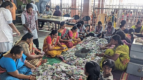 பழனி மலைக் கோயிலில் உண்டியல்கள் திறந்து எண்ணப்பட்டதில் காணிக்கையாக கிடைத்த ரூபாய் நோட்டுக்களை பிரிக்கும் பணியில் ஈடுபட்ட பணியாளா்கள். 