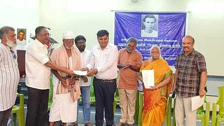 புதுமைப்பித்தன் நினைவு தின நிகழ்ச்சியில் எழுத்தாளா் வண்ணதாசனுக்கு புத்தகத்தை வழங்கிய மாவட்ட ஆட்சியா் கா.ப.காா்த்திகேயன். அருகில் ஓவியா் சந்ரு உள்ளிட்டோா். 