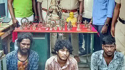 பறிமுதல் செய்யப்பட்ட ஐம்பொன் சிலைகள், அவற்றைத் திருடியதாக கைதானவா்களுடன் போலீஸாா்.