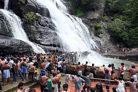 குற்றாலம் பேரருவியில் குளித்து மகிழும் சுற்றுலாப் பயணிகள்.