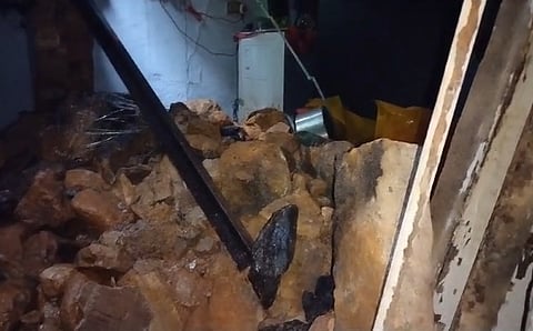 இடிந்து விழுந்த வீட்டின் சுவர்.