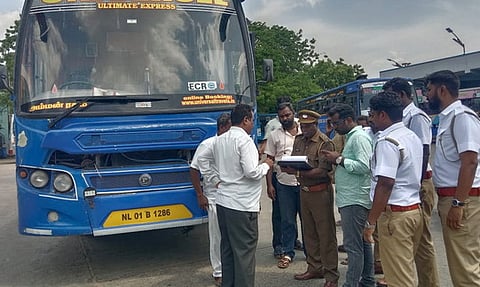  பேருந்து  நிலையத்தில் பேருந்து ஆவணங்களைப் பரிசோதித்த போக்குவரத்து அதிகாரிகள்.