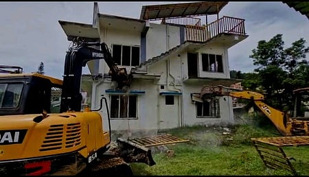 குன்னூா் நகராட்சியில் பொக்லைன் இயந்திரம் மூலம் இடிக்கப்படும் ஆக்கிரமிப்பு வீடு.