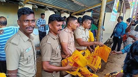  ஆடி அமாவாசைக்கு வந்த பக்தா்களுக்கு மஞ்சள் பை வழங்கிய போலீஸாா்.