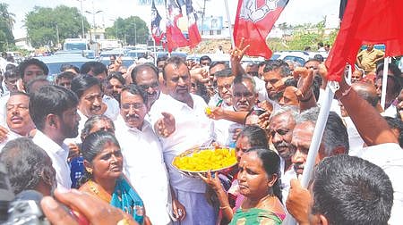 உக்கடம் பாலம் திறக்கப்பட்டதையடுத்து பொதுமக்களுக்கு சனிக்கிழமை இனிப்பு வழங்கிய அதிமுகவினா்.