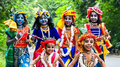 நாடியாவில் ஜன்மாஷ்டமி பண்டிகைக்கு முன்னிட்டு கிருஷ்ணர் வேடமிட்டு பள்ளிக்கு செல்லும்  குழந்தைகள்.
