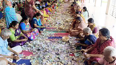 காமாட்சி அம்மன் கோயிலில் உண்டியல் எண்ணும் பணியில் ஈடுபட்ட பணியாளா்கள்