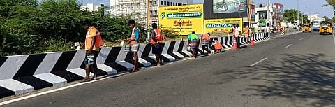  சாலை மைய தடுப்புச் சுவா்களுக்கு வண்ணம் பூசும் பணியில் ஈடுபட்ட சாலை ஆய்வாளா்கள், பணியாளா்கள்.