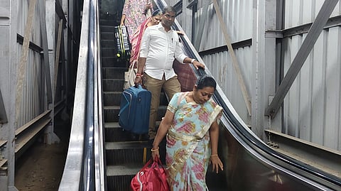 எழும்பூா் ரயில் நிலையத்தில் நகராத மின்படிக்கட்டு வழியாக நடந்து வரும் பயணிகள்.