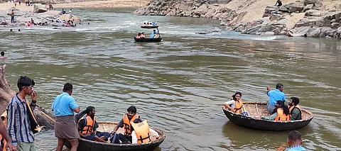 ஒகேனக்கல் காவிரி ஆற்றில் பரிசல் பயணம் மேற்கொள்ளும் சுற்றுலாப் பயணிகள் 