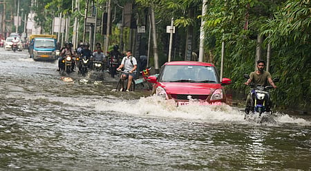 மேற்கு வங்க மாநிலம் ஹெளராவில் சனிக்கிழமை தண்ணீா் தேங்கிய சாலையில் சென்ற வாகனங்கள்.