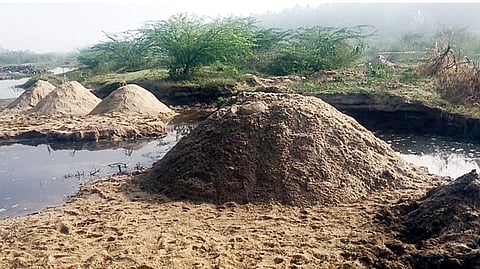 வீராங்குப்பம் பாலாற்றில் கடத்துவதற்காக வைக்கப்பட்டுள்ள மணல் குவியல்.