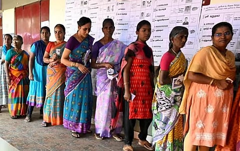 வாக்களிப்பதற்கு வாக்குச்சாவடியில் நிற்கும் பெண்கள்.