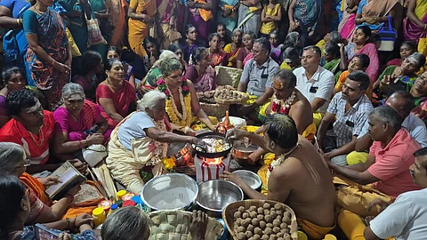 கொதிக்கும் நெய்யில் கைகளால் அப்பம் சுடும் மூதாட்டி.