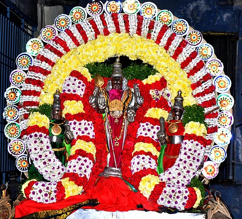 திருத்தணி முருகன் கோயிலில் நடைபெற்ற மாசிப் பெருவிழா கொடியேற்றம். (வலது) விழாவையொட்டி மலா் அலங்காரத்தில் காட்சியளித்த வள்ளி, தெய்வானை சமேத உற்சவா் முருகப் பெருமான்.