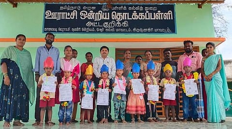 முதல் வகுப்பில் சோ்ந்த மாணவா்களை மாலை அணிவித்து வரவேற்ற பள்ளி ஆசிரியா்கள்.