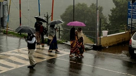 கோத்தகிரியில் மழையில் குடைபிடித்து செல்லும் பொதுமக்கள்