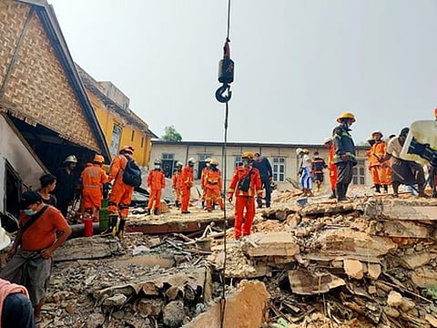 நிலநடுக்க இடிபாடுகளில் சிக்கியுள்ளவா்களை தேடும் பணியில் மீட்புக் குழுவினா்.